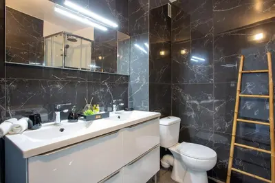 a bathroom with a sink and a toilet and a mirror at 4 pièces 8 personnes proche aéroport,tramway in Nice