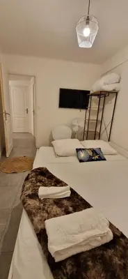 a room with two beds with towels on them at 4 pièces 8 personnes proche aéroport,tramway in Nice