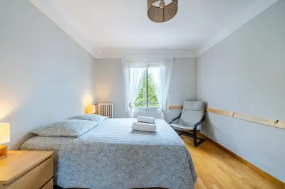 a bedroom with a bed and a chair and a window at Appartement en plein coeur de Cagnes sur Mer in Cagnes-sur-Mer