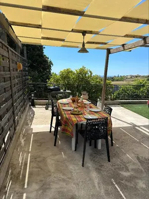a table and chairs under an umbrella on a patio at Villa de charme 6 Pièces avec Vue Mer sur les Hauteurs de Nice in Nice