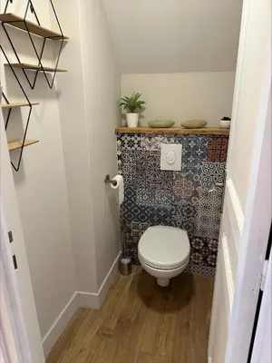 a bathroom with a toilet and a tile wall at Villa de charme 6 Pièces avec Vue Mer sur les Hauteurs de Nice in Nice