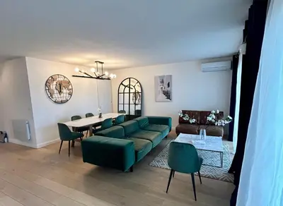 a living room with a green couch and a table at Sunny Days in Nice