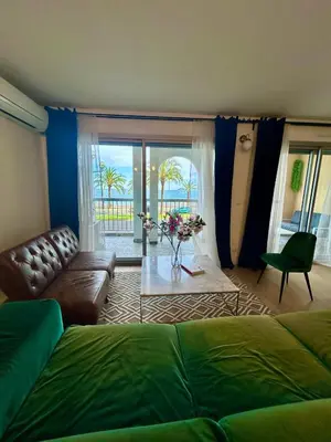 a living room with a couch and a living room with a view of the ocean at Sunny Days in Nice