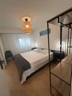 a bedroom with a bed and a chandelier at Sunny Days in Nice