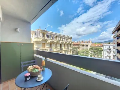 a table on a balcony with a view of a building at Nestor&Jeeves - POP ART - central - balcony in Nice