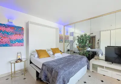a bedroom with a bed and a flat screen tv at Nestor&Jeeves - POP ART - central - balcony in Nice