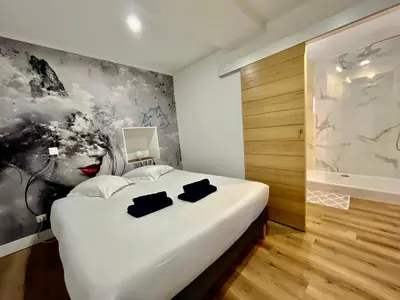a bedroom with a white bed with a painting on the wall at Old Town Lovely Apartment in Nice in Nice
