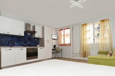 a kitchen with white cabinets and a green couch at Blue Lagon Five Stars Holiday House in Nice