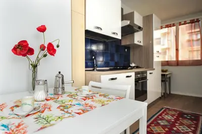a kitchen with a table with a vase of flowers on it at Blue Lagon Five Stars Holiday House in Nice