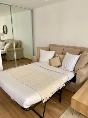 a bed sitting in a living room with a couch at Studio centre-ville Beaulieu-sur-Mer in Beaulieu-sur-Mer