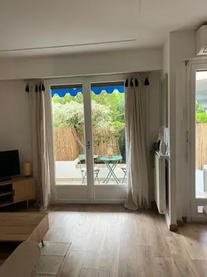 a living room with a sliding glass door to a patio at Studio centre-ville Beaulieu-sur-Mer in Beaulieu-sur-Mer