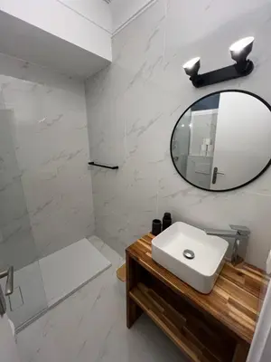 a white bathroom with a sink and a mirror at Studio centre-ville Beaulieu-sur-Mer in Beaulieu-sur-Mer