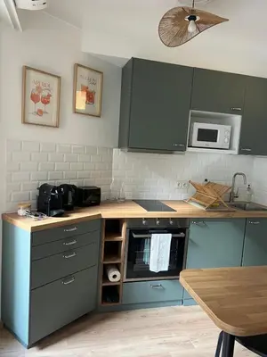 a kitchen with green cabinets and a wooden counter top at Studio centre-ville Beaulieu-sur-Mer in Beaulieu-sur-Mer