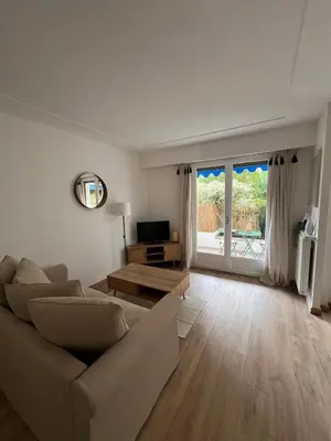 a living room with a couch and a television at Studio centre-ville Beaulieu-sur-Mer in Beaulieu-sur-Mer