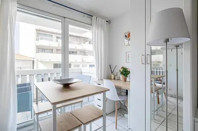 a dining room with a table and a balcony at Charming Studio with pool & balcony -Heart of Nice in Nice