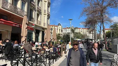 a group of people walking down a city street at Nice center Aviva's-home in Nice