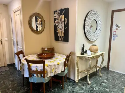 a dining room with a table and chairs and a mirror at Nice center Aviva's-home in Nice