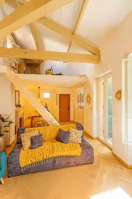 a large yellow couch in a living room with a table at Le Grand Ruisseau in Nice