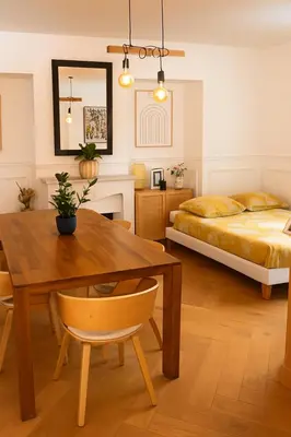 a bedroom with a dining room table and a bed at Le Grand Ruisseau in Nice