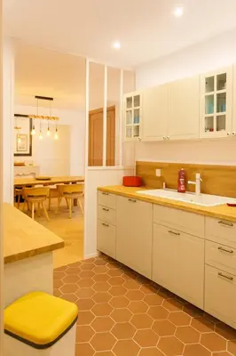a kitchen with white cabinets and a yellow stool at Le Grand Ruisseau in Nice