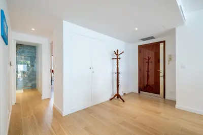 a hallway with white walls and a wooden floor at Magnifique T2, parking, face mer in Cagnes-sur-Mer