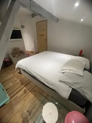 a bedroom with a large white bed and a wooden floor at Duplex quatre pièces - une chambre bébé à 5 minutes de la plage in Nice