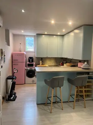 a kitchen with a counter and a pink refrigerator at Duplex quatre pièces - une chambre bébé à 5 minutes de la plage in Nice