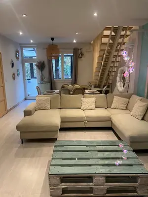 a living room with a couch and a staircase at Duplex quatre pièces - une chambre bébé à 5 minutes de la plage in Nice
