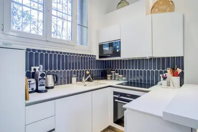 a white kitchen with white cabinets and appliances at 4 stars Palais Hermitage, 5 pers, AC, Full confort in Nice