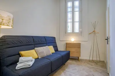 a blue couch in a living room with a window at 4 stars Palais Hermitage, 5 pers, AC, Full confort in Nice