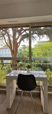 a white desk with a chair in front of a window at 2 pièces au calme avec terrasse et climatisation in Nice