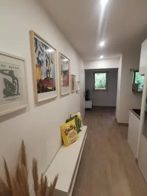 a room with a white wall with paintings on it at 2 pièces au calme avec terrasse et climatisation in Nice