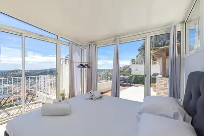 a bedroom with a bed and a large window at 73 CORNE D OR - Toit Terrasse - Vue Mer Panoramique - Jaccuzzi in Villefranche-sur-Mer