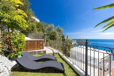 a group of benches sitting next to the ocean at 73 CORNE D OR - Toit Terrasse - Vue Mer Panoramique - Jaccuzzi in Villefranche-sur-Mer