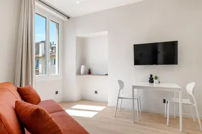 a white living room with a couch and a table at RIVIERA COZY - Place Massena in Nice