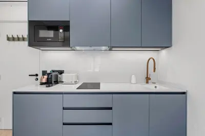 a kitchen with white cabinets and a sink at RIVIERA COZY - Place Massena in Nice