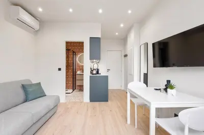 a white living room with a couch and a table at RIVIERA COZY - Place Massena in Nice