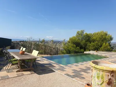 a table and chairs next to a swimming pool at Villa moderne avec piscine vue mer à Nice Bellet in Nice