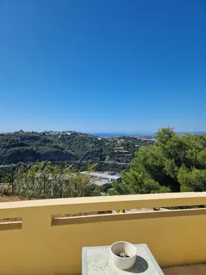 a coffee cup sitting on a table on a balcony at Villa moderne avec piscine vue mer à Nice Bellet in Nice