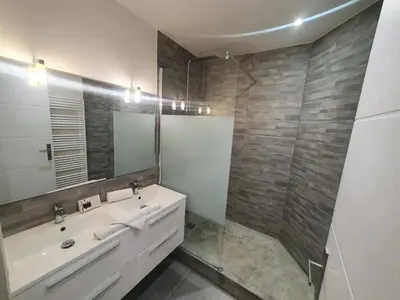 a bathroom with a sink and a glass shower at Loft - 