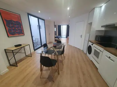 a kitchen and living room with a table and chairs at Loft - 