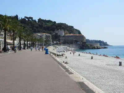 a beach with people laying on the sand and the water at Magnifique 2p au coeur du vieux Nice in Nice