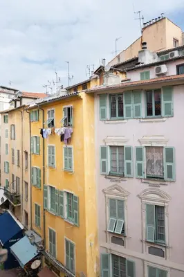 a group of buildings with green and yellow windows at Magnifique 2p au coeur du vieux Nice in Nice
