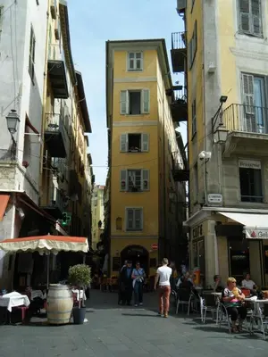 a group of people walking down a street with buildings at Magnifique 2p au coeur du vieux Nice in Nice