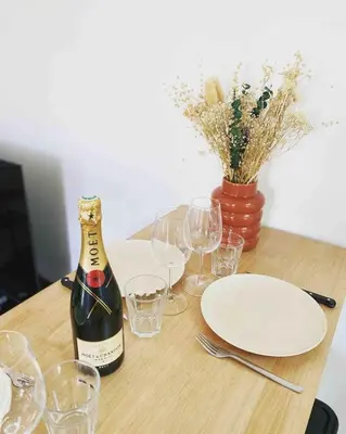 a bottle of wine sitting on a table with glasses at Beautiful refurbished cozy apartment in Nice
