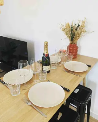 a table with plates and glasses and a bottle of wine at Beautiful refurbished cozy apartment in Nice