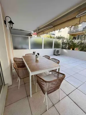 a wooden table and chairs on a patio at Beautiful apartment - Centre in Cagnes-sur-Mer