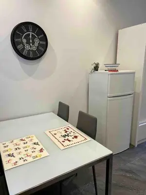 a white table with a black clock on a wall at Massena : Hyper Centre Studio 2p in Nice