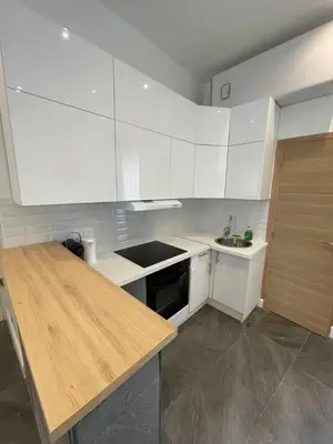 a kitchen with white cabinets and a wooden counter top at Massena : Hyper Centre Studio 2p in Nice