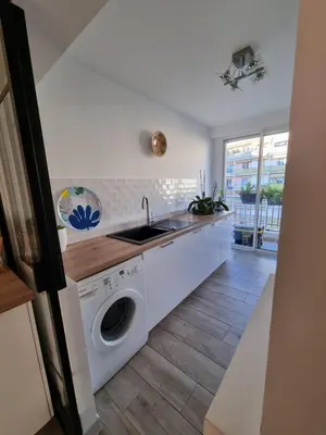 a kitchen with a sink and a washing machine at Magnifique T3, spacieux, lumineux et traversant in Nice